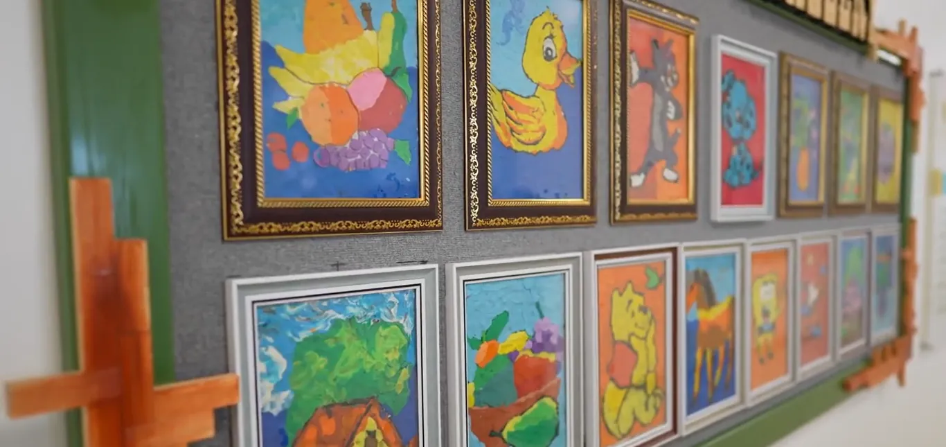 Children’s artwork framed on a school wall